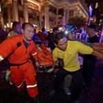 Rescue workers carried an injured person after a bomb exploded at a religious shrine in central Bangkok late Monday.