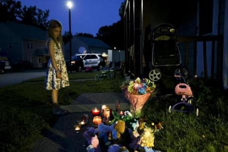 A girl stood at the makeshift memorial outside the home in Auburn.

