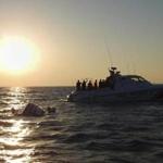 Officers on board a Turkish coast guard boat watched as a capsized motorboat floated in the Aegean Sea, close to the town of Bodrum, Turkey. 