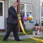 Auburn Police Detective Sergeant Scott Mills took down crime scene tape in the front yard of the Auburn home on Wednesday.
