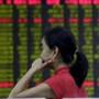 An investor looked at an electronic board showing stock information at a brokerage house in Beijing on Wednesday.