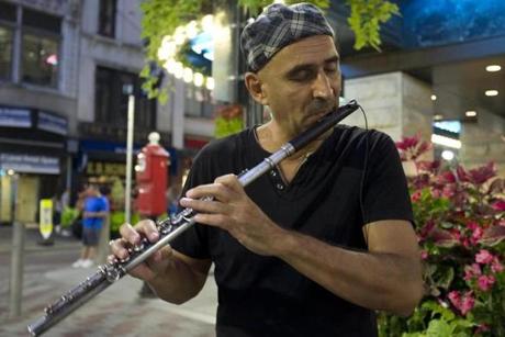 Flutist Boris Popovich performed Monday at Summer and Washington streets, the first time he performed since suffering injuries in May when a tree fell on his car.
