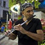 Flutist Boris Popovich performed Monday at Summer and Washington streets, the first time he performed since suffering injuries in May when a tree fell on his car.
