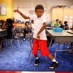 Second grader Aiden Greene, 7, practices his dance moves before a GoNoodle break during the first day of class at Salemwood School in Malden. 