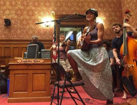 Krista Speroni strums her guitar inside Cambridge City Hall with her band Woven.
