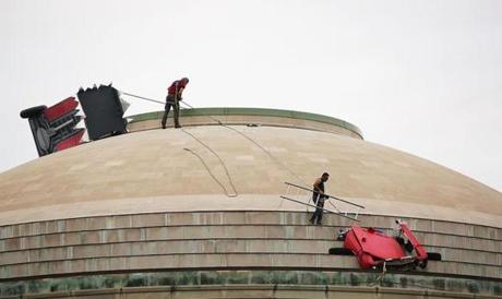 Workers removed items from MIT's Great Dome on Friday.
