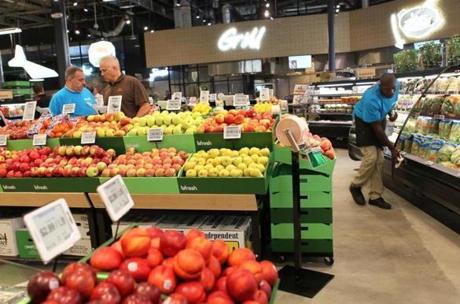 Workers arranged vegetables and fruit in the produce section as they prepared for the opening of the bfresh grocery store Friday.
