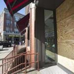 A window near the door of the main ticket office on Yawkey Way was damaged and boarded up until it can be replaced.