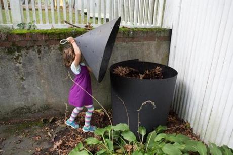 Abby Edelstein, 5, closed the lid on her back yard compost pile in Newton.
