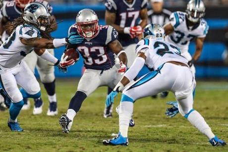 Aug 28, 2015; Charlotte, NC, USA; New England Patriots running back Dion Lewis (33) tries to elude Carolina Panthers cornerback Melvin White (23) during the second half at Bank of America Stadium. New England wins 17-16 over the Panthers. Mandatory Credit: Jim Dedmon-USA TODAY Sports
