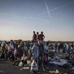 Migrants waited for buses at a makeshift camp just north of the border with Serbia near Roszke, Hungary on Wednesday.