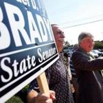 State Representative Michael Brady (right) waved to cars passing by as he campaigned for an open state senate seat. 