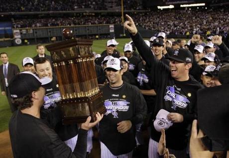 Colorado Rockies' players celebrate with the National League Championship Series trophy after winning Game 4 of Major League Baseball's NLCS playoff series against the Arizona Diamondbacks in Denver October 15, 2007. REUTERS/Pool (UNITED STATES)

