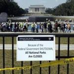 In this Oct. 2013 file photo, despite signs stating that the national parks are closed because of the government shutdown, people visited the World War II Memorial in Washington. 