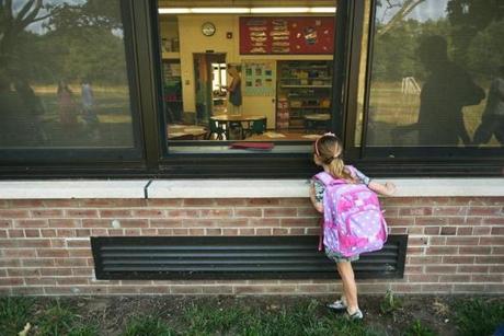 A student peeks into her classroom as she waits for the first day of school at the Alexander Hamilton School in Glen Rock, N.J. on Sept. 2.
