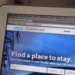 The Airbnb website is displayed on a laptop.