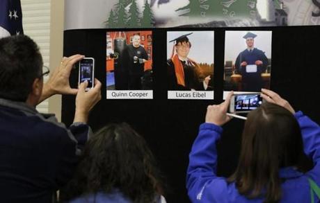 Reporters copy photographs of three of the victims of the mass shooting at Umpqua Community College that were displayed at a Friday news conference.
