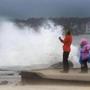 Tourists watched as waves battered the beach in Ocean City, Md., on Saturday. Hurricane Joaquin could produce high surf and rip currents throughout the East Coast, forecasters said