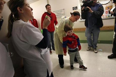 Christian Caruso, 4, got assistance from his physical therapist, Colleen Farrell, as he left the hospital while staff blew bubbles for him. 
