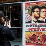 A woman took a photo of a poster for the film, ?The Interview,? outside of Regal Theater in New York in December 2014.