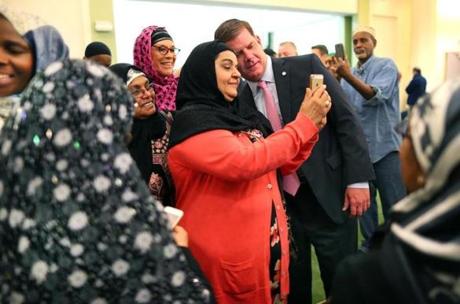 Mayor Walsh snapped a selfie (top) and spoke to worshipers at the Islamic Society of Boston Cultural Center.
