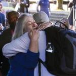 Rita Cavin, president of Umpqua Community College, hugged a visitor to the campus Monday as classes reopened.