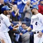 Kansas City?s Alex Gordon (right) was greeted by teammate Alcides Escobar after scoring during a five-run seventh inning.