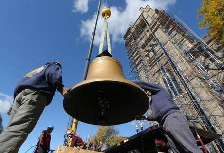 Workers prepared one of the historic bells to be hoisted. 
