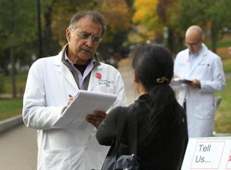 Doctors Vikas Saini (left) and Aaron Stupple wrote down the health care stories that they heard from passersby.
