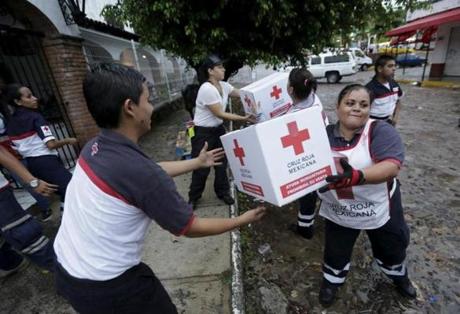 Red Cross volunteers load humanitarian aid boxes from a truck in the Pacific beach resort of Puerto Vallarta, Mexico October 24, 2015. Patricia, one of the strongest ever hurricanes, crashed into western Mexico with rain and winds of up to 165 mph (266 kph), hammering coastal areas but skirting major cities and causing less damage than feared. Mowing down trees, flooding streets and battering buildings, Hurricane Patricia plowed into Mexico as a Category 5 storm on Friday evening before grinding inland. It rapidly lost power in the mountains that rise up along the Pacific coast and was downgraded to a tropical storm by Saturday morning. REUTERS/Henry Romero
