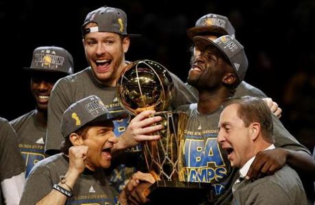 CLEVELAND, OH - JUNE 16: Draymond Green #23 David Lee #10 and Andrew Bogut #12 of the Golden State Warriors celebrates with team owners Peter Guber and Joe Lacob and the Larry O'Brien NBA Championship Trophy after defeating the Cleveland Cavaliers 105 to 97 to win Game Six of the 2015 NBA Finals at Quicken Loans Arena on June 16, 2015 in Cleveland, Ohio. NOTE TO USER: User expressly acknowledges and agrees that, by downloading and or using this photograph, user is consenting to the terms and conditions of Getty Images License Agreement. (Photo by Ezra Shaw/Getty Images)
