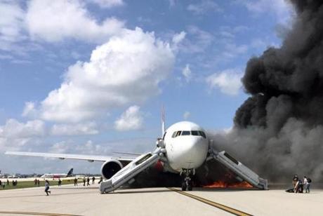 Passengers evacuated from a plane on fire at Fort Lauderdale airport.
