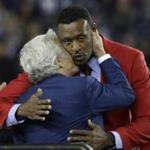 New England Patriots owner Robert Kraft, left, kisses former Patriots standout linebacker Willie McGinest as he is honored during the halftime of an NFL football game between the Patriots and Miami Dolphins, Thursday, Oct. 29, 2015, in Foxborough, Mass. (AP Photo/Steven Senne)