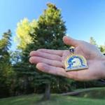 Bill MacEachern held his medal from the 100th Boston Marathon while standing near the tree selected for Boston.