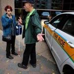 Passenger Mandi Curtis, of Roxbury, talked with The Ride driver Manny Rebello outside Boston Medical Center.