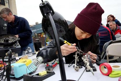 Christina Lively, Dina Gjertsen, and Erin Geno examine a sewing machine at the Fixer Fair in Somerville. 
