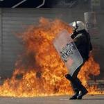 A riot policeman tried to avoid a petrol bomb thrown by protesters during a rally in Athens on Thursday.