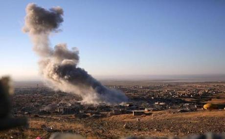 Smoke believed to be from an airstrike billowed over the northern Iraqi town of Sinjar on Thursday.
