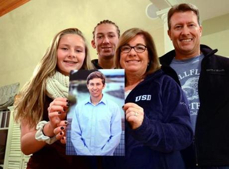 Hingham 11/02/2015: University of San Diego freshman Tom Noonan's family: (l-R) Meredith Noonan, 15, Jack, 18, mother Mal and father Phil with a picture of Tom. Photo by Debee Tlumacki for the Boston Globe (regional) 

