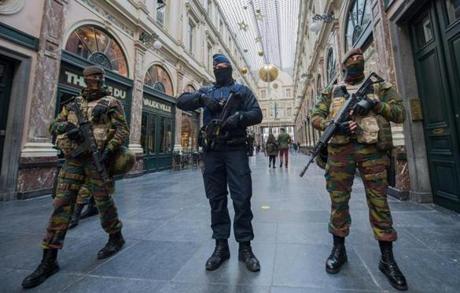 epa05037202 Police officer and soldiers on security duty inside Galerie de la Reine following the terror alert level being elevated to 4/4, in Brussels, Belgium, 22 November 2015. Belgium raised the alert status to maximum because of a 'serious and imminent' threat of an attack. The Metro line remains closed and all Belgian league one and two soccer matches have been cancelled. The Belgian government said it had concrete evidence of a planned terrorist attack that would have employed weapons and explosives. EPA/STEPHANIE LECOCQ

