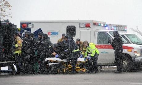 Emergency personnel transported an officer to an ambulance after reports of a shooting near a Planned Parenthood clinic Friday in Colorado.
