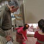 Former Governor Michael Dukakis helped his neighbors, Lilac and Isabella Nguyen, get the donated turkey carcasses into a freezer. 