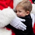 Micah Burtt, 3, gave Globe Santa a hug during a visit at Faneuil Hall Marketplace on Friday.