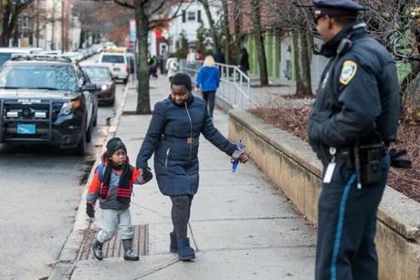 Cambridge Officer Adam Betts greeted parents and students outside the combined entrance of the Putnam Ave Upper School and the Kennedy-Longfellow School on Spring Street in Cambridge. 
