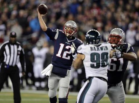 New England Patriots quarterback Tom Brady (12) throws a touchdown pass over Philadelphia Eagles linebacker Connor Barwin (98) during the first half of an NFL football game, Sunday, Dec. 6, 2015, in Foxborough, Mass. (AP Photo/Charles Krupa) 
