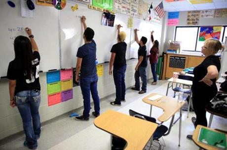 Teacher Marcia Ziegler (right) observed calculus students at PSJA Early College High School as they solved equations. 
