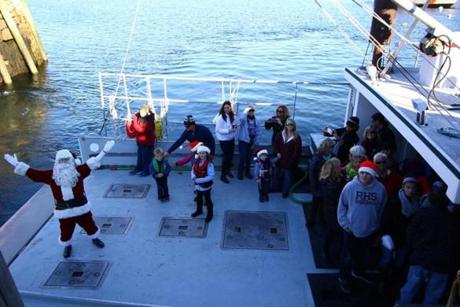 Santa arrives to the T-Wharf in Rockport on Saturday, December 5, 2015 by lobster boat, to a crowd of families anxiously awaiting to see him. Mark Lorenz for the Boston Globe

