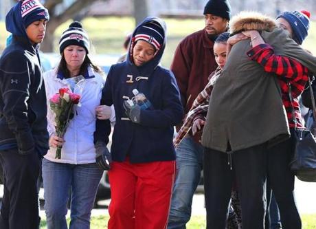 Boston12/19/15 Seventeen-yr-old D'Andre King-Settles was shot and killed Friday night on Annunciation Road as his mother (center)is helped to a makeshift memorial of candles on the ground in his honor. Boston Globe staff photo by John Tlumacki(metro)
