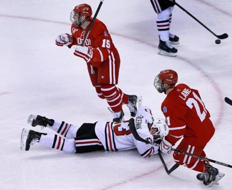 02/23/15: Boston, MA: NU's Colton Saucerman is down and out as BU's Nick Roberto (15) and Matt Lane start the celebration following a second period goal by teammate Matt Grzelcyk (not pictured) that put the Terriers ahead 3-1. Northeastern University and Boston University met in the Beanpot Championship game at the TD Garden. (Globe Staff Photo/Jim Davis) section:sports topic: Beanpot (1)
