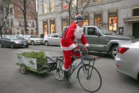 Jimmy Rider pedaled through Boston toward Copley Square with a Christmas tree in tow. Rider has delivered 200 trees this season.
